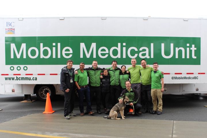 Mobile Medical Unit staff posing in front of MMU logo